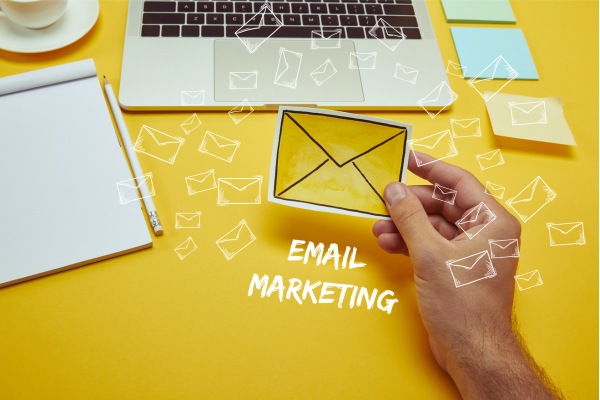 Hand holding envelope icon representing email marketing campaign