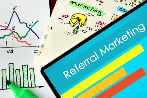 Tablet screen showing referral marketing graph and performance charts